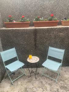dos sillas y una mesa con un vaso junto a una pared en Beautiful 2-Bed House in Larne with free parking, en Larne