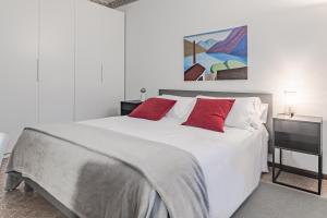 a bedroom with a white bed with red pillows at Ca' Maria Acero by Wonderful Italy in Bellagio