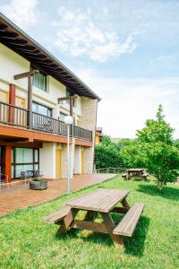 a wooden picnic table in the grass next to a building at Apartamentos Aldea del Puente in Cangas de Onís