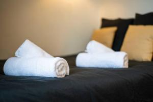 zwei gerollte Handtücher auf dem Bett in der Unterkunft Le pragmatique in Évreux
