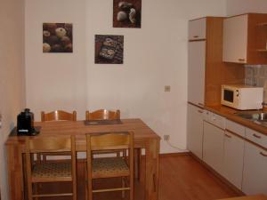 Apartment Seeblick Wetter في ويتير: مطبخ مع طاولة وكراسي وميكروويف