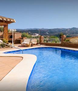 a swimming pool with blue water in a yard at Slow Axarquía in Torre de Benagalbón
