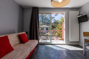 a living room with a couch and a sliding glass door at Résidence Maminotte in La Teste-de-Buch