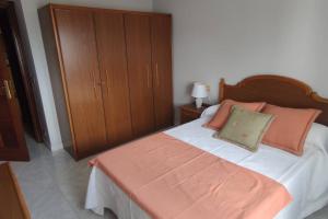 um quarto com uma cama com uma cabeceira e almofadas de madeira em Piso turístico Dena em Pontevedra