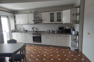 uma cozinha com armários brancos e uma mesa em Piso turístico Dena em Pontevedra