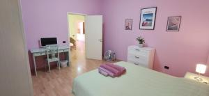 een slaapkamer met paarse muren, een bed en een bureau bij Family and friends house in Lecce