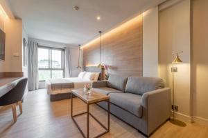 a living room with a couch and a bed at Espahotel Plaza de España in Madrid