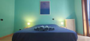 een slaapkamer met een blauw bed en handdoeken bij Family and friends house in Lecce