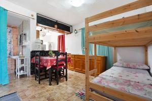1 dormitorio con litera y comedor con mesa en Majada Blanca, en Valles de Ortega