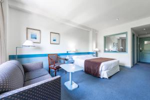 una camera d'albergo con letto e divano di Espahotel Plaza de España a Madrid