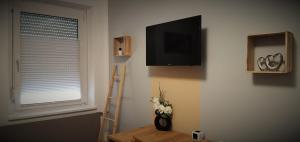 a room with a television and a table with flowers at Haus im Seegebiet von Villach in Villach