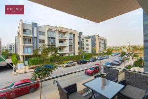 a balcony with a table and chairs and a street with cars at Prime Select Galleria New Cairo in New cairo