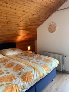 a bed in a bedroom with a wooden ceiling at B&B Oostkapelle aan Zee in Oostkapelle