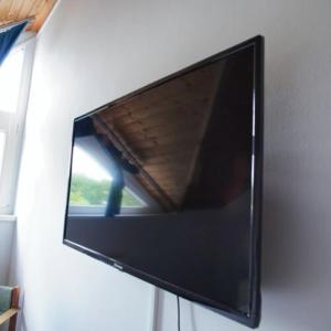 a flat screen tv hanging on a wall at Villa Bea Panzió in Zamárdi