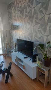 salon z telewizorem na białej szafce w obiekcie double room with private bathroom w mieście Arrentela