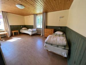1 Schlafzimmer mit 2 Betten und Holzdecke in der Unterkunft Skagagården, Mossen in Undenäs