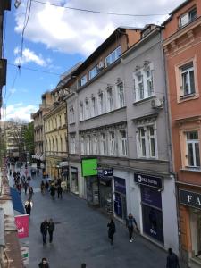 un grupo de personas caminando por una calle con edificios en Apartment Amra, en Sarajevo