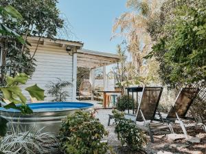 un cortile con piscina, sedie e una casa di Eili Suites a Moshav Ramot