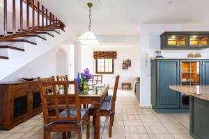 a kitchen with a table and chairs and a staircase at Live Santa Úrsula Cala in Santa Úrsula