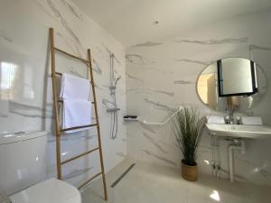 een badkamer met een wastafel en een spiegel bij Les Loges de la Mer - Pérols in Pérols