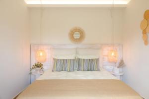 a bedroom with a large white bed with a mirror at Anatolikos Beach House in Alykes