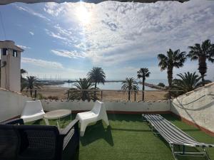 a balcony with chairs and tables and a view of the beach at Beachfront vila in Valencia