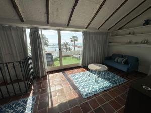 sala de estar con sofá azul y ventana grande en Beachfront vila, en Valencia