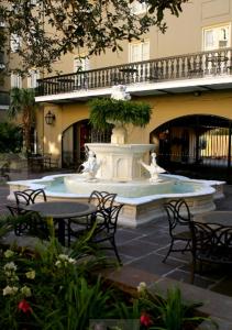ニューオーリンズにあるメゾン デュピュイ ホテルのテーブルと椅子が備わる建物前の噴水