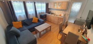 a living room with a blue couch and a kitchen at VACATION STUDIO OROPOS in Néa Palátia