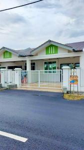 Homestay Intan Anjung Lodge في ميلاكا: مبنى ابيض امامه سياج