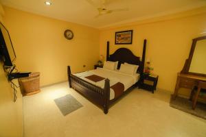 a bedroom with a bed and a clock on the wall at HOTEL UDUPI INTERNATIONAL in Nāgercoil