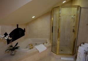 
a bathroom with a shower stall and a tub at Maison Dupuy Hotel in New Orleans
