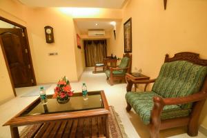a living room with a chair and a coffee table at HOTEL UDUPI INTERNATIONAL in Nāgercoil