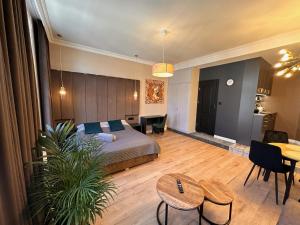 a bedroom with a bed and a living room with a table at DK Premium Warmińska Secesja in Olsztyn