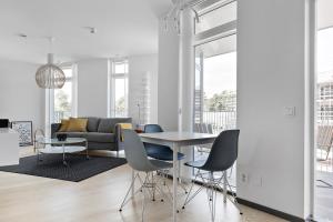 een woonkamer met een tafel en stoelen en een bank bij ÅhusBrygga Apartment Hotel in Åhus