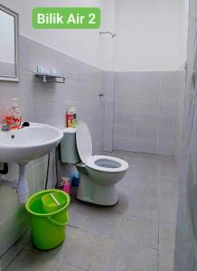 a bathroom with a white toilet and a sink at Homestay Intan Anjung Lodge in Melaka