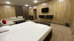 Habitación de hotel con cama y TV en JINJU en Yakkasaray