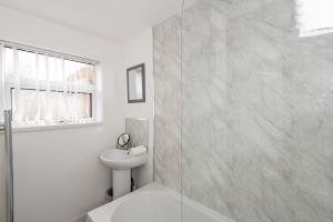 Spacious 3-Bedroom Home, Newly Renovated, Sleeps 5 في سندرلاند: حمام أبيض مع حوض ومرحاض