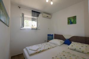 ein kleines Schlafzimmer mit einem Bett und einem Fenster in der Unterkunft Apartment Zinka in Šilo