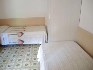 a room with two beds and a person laying on the bed at Nice flat with terrace in a great spot - Beahost in Bibione