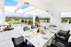a white dining room with a table and chairs at Villa Nikoli in Kolymbia