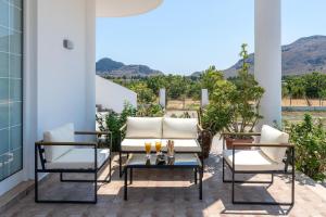 a patio with two chairs and a table with candles at Villa Nikoli in Kolymbia