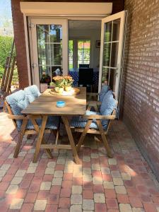 a wooden table and chairs on a patio at B&B Oostkapelle aan Zee in Oostkapelle