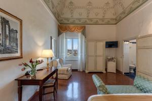 ein Wohnzimmer mit einem Tisch und einem Sofa in der Unterkunft Hotel Palazzo di Valli in Siena