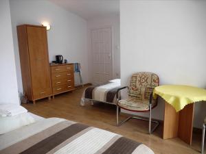1 dormitorio con 2 camas, silla y cómoda en Bursztyn, en Rewal