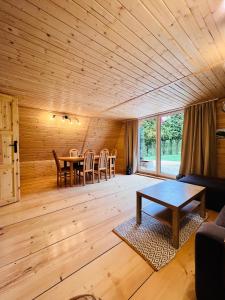 a living room with a wooden ceiling and a table at Domek nad Potokiem w Beskidach in Rajcza