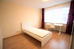 a bedroom with a bed and a table and a window at Varpo st 10 Kaunas Students Home LT in Kaunas