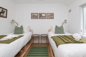 two beds in a room with green and white pillows at Brett Stays - King Weston Abode in Avonmouth