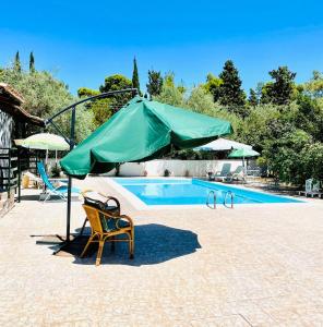 un ombrellone verde e una sedia accanto alla piscina di I mori di Sicilia Relais Charme ad Altavilla Milicia