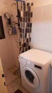 a washing machine in a bathroom with a shower at Studio Hadera in H̱adera